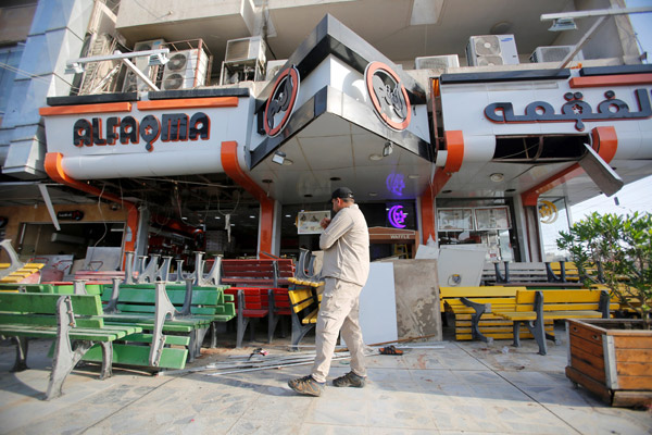  Seorang lelaki meninjau keadaan di tempat kejadian bom kereta berhampiran kafe aiskrim di Baghdad, semalam. — Gambar Reuters