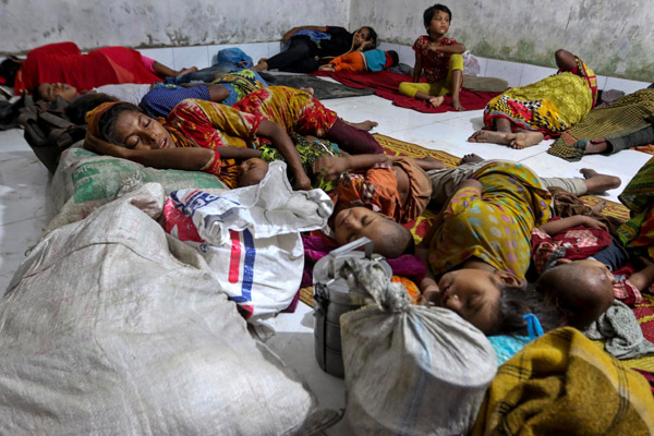  Penduduk kampung tidur di pusat perlindungan siklon setelah dipindahkan pihak berkuasa dari kampung pesisiran pantai di daerah Cox’s Bazar, kelmarin menjelang kemaraan Mora. — Gambar AFP