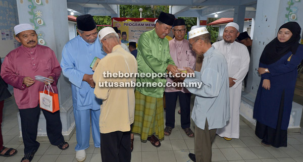  Sapawi dan Ahmad menyampaikan sumbangan kepada wakil masjid dan surau bagi DUN Sindumin.