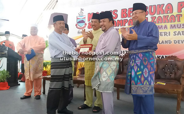  Abdul Rahim (dua kanan) menyampaikan bantuan kepada Pertubuhan Taman Cahaya sambil diperhatikan Musa (tiga kanan) dan Jazuli (kanan).