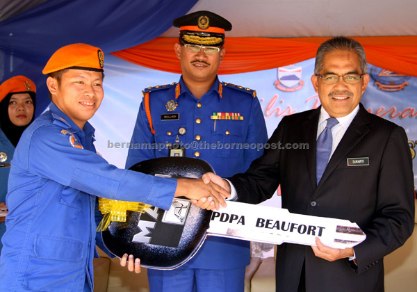  Sukarti (kanan) menyerahkan Kenderaan Operasi dan Logistik Bencana Angkatan Pertahanan Awam Malaysia (APM) Fasa Pertama kepada wakil Pejabat Daerah Pertahanan Awam Beaufort semalam. Turut hadir Mulliadi (tengah). — Gambar Bernama 