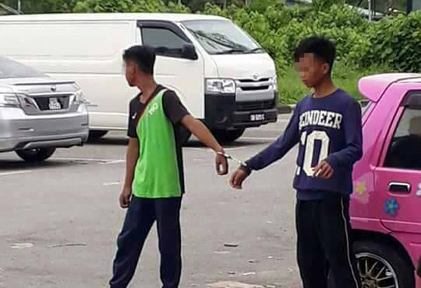  Dua daripada suspek kes vandalisme ketika ditahan polis. — Gambar sumber media sosial