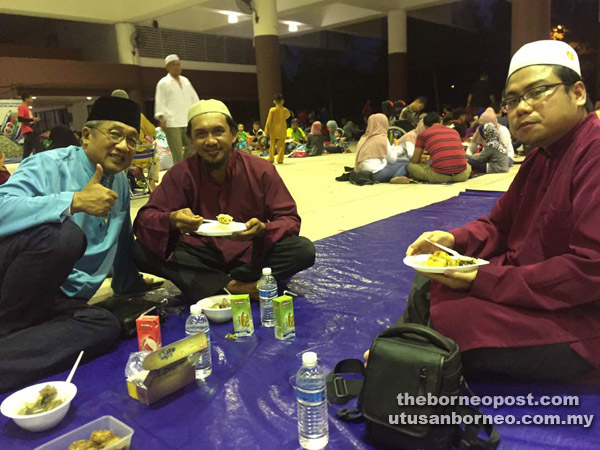  Muhamad Yakup (kiri) berbuka puasa  bersama penduduk setempat di Dewan Suarah Bintulu.