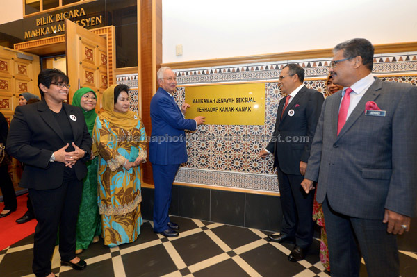  Najib (empat kiri) menunjukkan plak Mahkamah Jenayah Seksual terhadap Kanak-Kanak selepas merasmikan mahkamah yang pertama seumpamanya di Malaysia dan Asia Tenggara itu di Istana Kehakiman di Putrajaya semalam. — Gambar Bernama