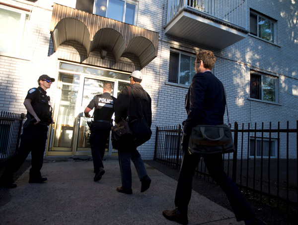  Penyiasat polis berjalan masuk ke kediaman Ftouhi di Montreal, Quebec, Kanada, kelmarin selepas Ftouhi dikenal pasti sebagai suspek oleh FBI dalam serangan pisau terhadap seorang anggota polis di lapangan terbang di Flint, Michigan. — Gambar Reuters