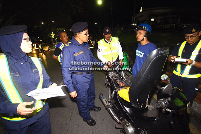  Syafiq (dua kiri) menyoal seorang penunggang motosikal yang diperiksa pada operasi malam kelmarin.