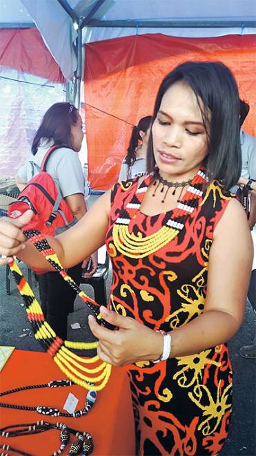  Lucy menunjukkan hasil unik kraf manik perhiasan wanita suku kaum Bidayuh Jagoi yang dibuatnya sendiri untuk lensa Utusan Borneo.