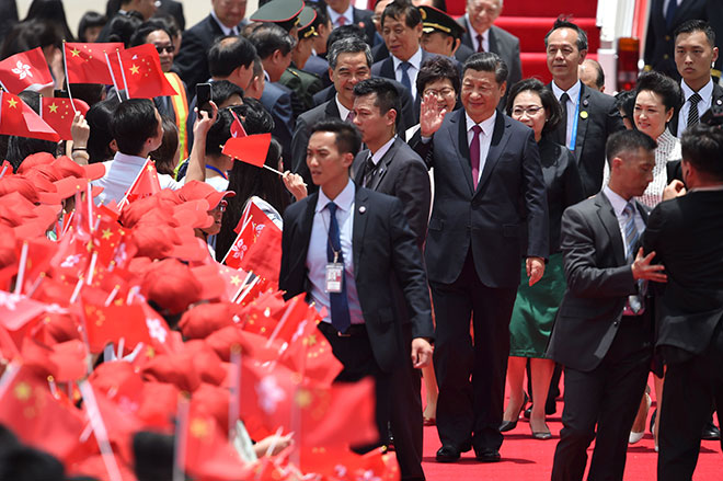  Xi (tengah) melambai kepada orang ramai yang menyambut ketibaannya di Lapangan Terbang Antarabangsa Hong Kong semalam. — Gambar AFP