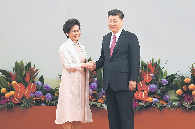  Xi berjabat tangan dengan Lam (kiri) sejurus upacara angkat sumpah jawatan di Pusat Pameran dan Konvensyen di Hong Kong, semalam. — Gambar AFP