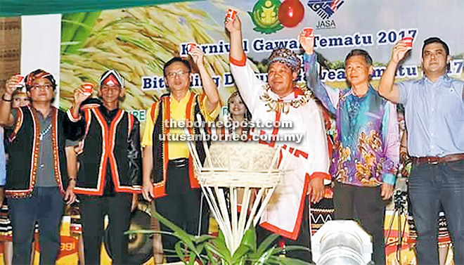  Lo (tiga kiri) dan John (tiga kanan) bersama tetamu yang lain melakukan upacara minum air tuak sebagai tanda sambutan Hari Gawai.