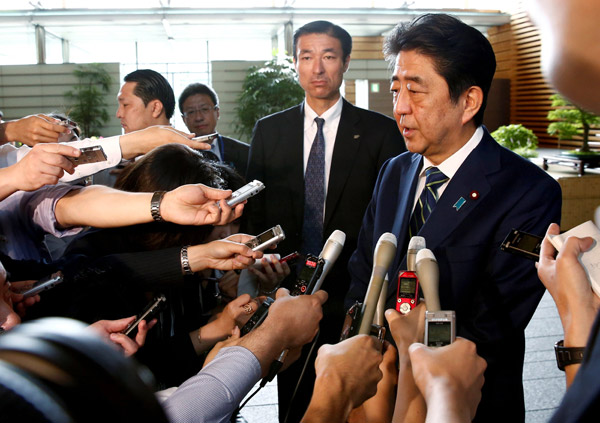  Abe bercakap kepada para wartawan sejurus tiba di pejabatnya di Tokyo, semalam. — Gambar Reuters