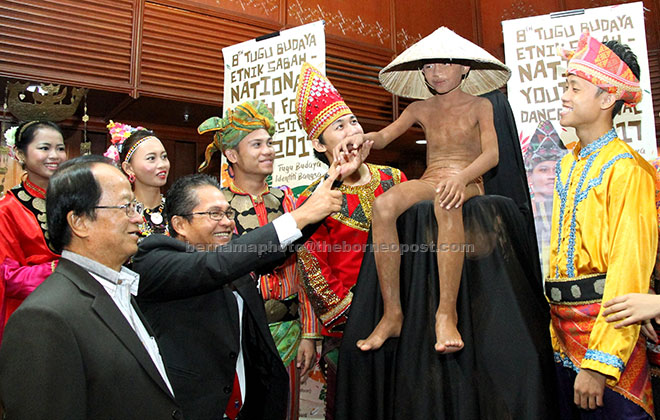  Rusmadi (dua kiri) bersama Wences (kiri) melihat maskot Tugu Siningazanak yang asalnya diambil daripada patung Siningazanak etnik Dusun dari Daerah Telipok yang merupakan simbol bagi keluarga yang tidak mempunyai anak sebagai pewaris harta terutamanya tanah pusaka di Kota Kinabalu, semalam. — Gambar Bernama