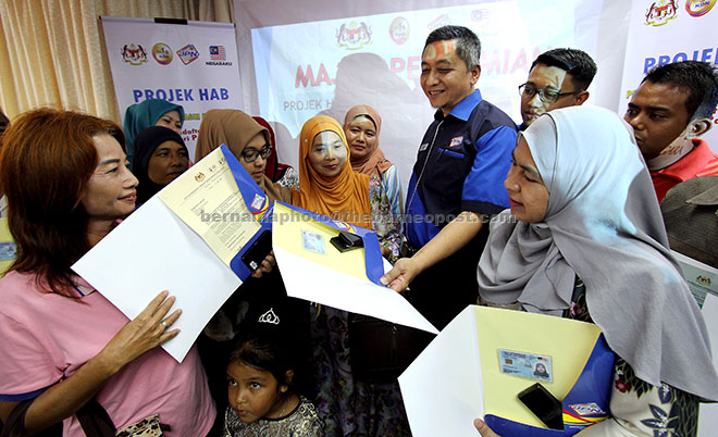  Mohd Yazid (empat kanan) melihat MyKad yang diterima salah seorang pemohon selepas merasmikan Hab Pencetakan Teragih JPN Negeri Pahang di JPN daerah Pekan, semalam. Turut hadir Timbalan Pengarah JPN negeri Nazrifairuz Mahmod (kanan). — Gambar Bernama