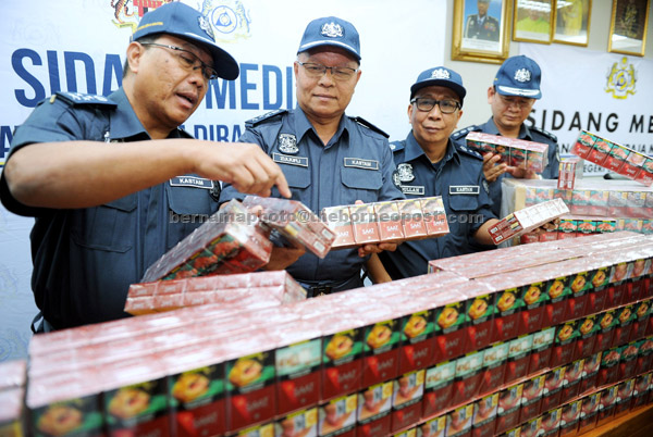  Zulkifli (tengah) menunjukkan sebahagian daripada 8.98 juta batang rokok jenama ‘SAAT’ membabitkan nilai cukai RM7 juta yang dirampas dari sebuah kapal kargo ketika mengadakan sidang media di Seremban semalam. — Gambar Bernama