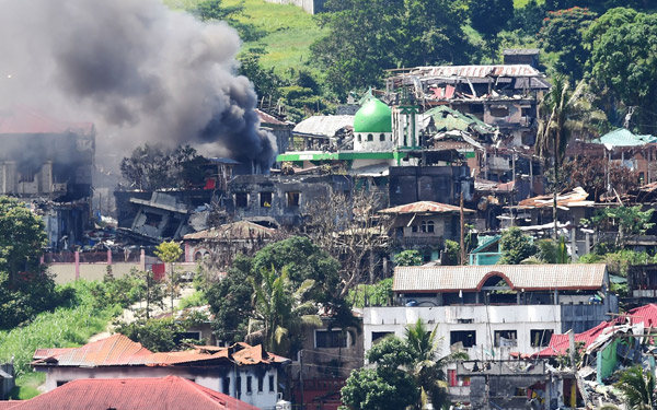  Gambar fail 26 Jun lalu menunjukkan asap berkepul dari sebuah rumah yang terbakar selepas jet pejuang tentera kerajaan melancarkan pengeboman ke atas kedudukan militan di Marawi, pulau selatan Mindanao. — Gambar AFP
