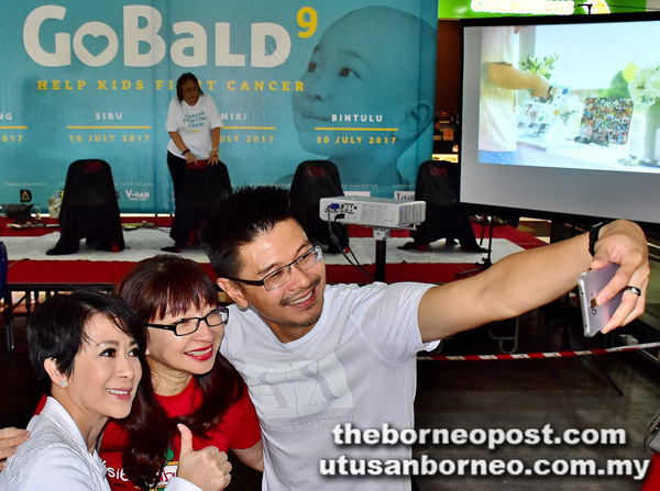  (Dari kiri) Lorna, Wong dan Andrew merakam gambar kenangan sebelum memulakan acara ‘Go Bald’.