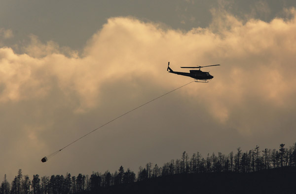  Helikopter turut menyertai usaha memadamkan kebakaran hutan di bandar Cache Creek, British Columbia di Kanada pada 18 Julai. — Gambar Reuters