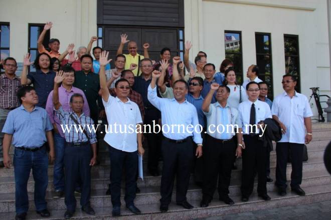 Henry (tengah) bersama komuniti Bisingai di luar Mahkamah Kuching selepas sebulat suara menarik balik tuntutan mahkamah terhadap kerajaan negeri berhubung isu tanah Pimu'ung.