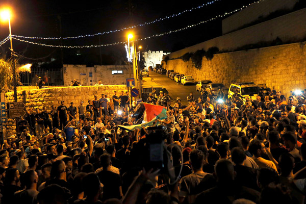  Penduduk Palestin meraikan di luar pintu masuk ke Kota Lama Baitulmaqdis selepas Israel menanggalkan alat kawalan keselamatan semalam. — Gambar Reuters