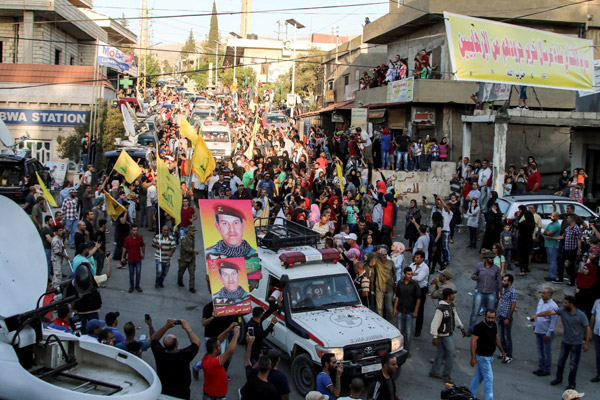  Konvoi ambulans membawa mayat pejuang Hizbullah memasuki kampung al-Labweh di Baalbek-Hermel kelmarin dengan disambut penduduk tempatan dan pejuang. — Gambar AFP