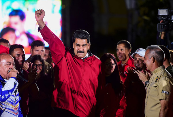  Maduro (tengah) dan para penyokongnya bersorak-sorai meraikan keputusan Dewan Perlembagaan di Caracas, semalam. — Gambar AFP