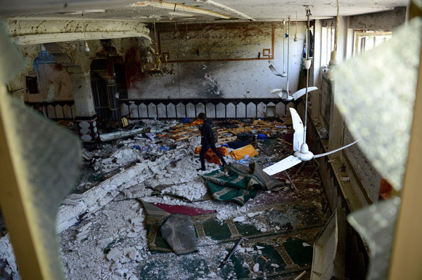  Seorang pegawai media tempatan meninjau keadaan di dalam masjid Syiah yang diserang pengebom nekad di Herat, semalam. — Gambar AFP
