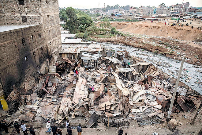  Penduduk Kikuyu hanya mampu melihat kemusnahan pondok kediaman mereka angkara penduduk Luo di kawasan setinggan Mathare di Nairobi, semalam. — Gambar AFP