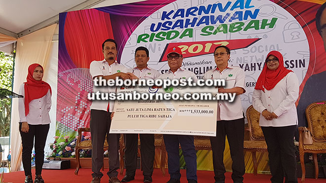  Yahya (tiga kanan) menyampaikan replika cek peruntukan Program Pembangunan Usahawan RISDA Sabah bagi tahun ini kepada Maizal.