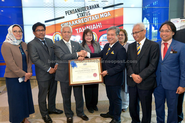  Idris menyampaikan sijil perakuan Status Swaakreditasi dari Agensi Kelayakan Malaysia (MQA) kepada Mazlihan dan Azanam (dua kanan) di Kementerian Pendidikan Tinggi (KPT), Putrajaya, semalam. — Gambar Bernama