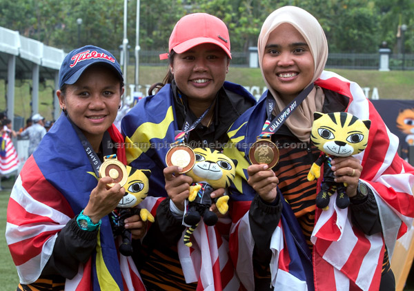  Pasukan memanah wanita negara (dari kiri) Fatin, Saritha dan Nurul Syazhera menunjukan pingat emas yang dimenangi di Padang Sintetik Bukit Jalil, Bandar Sukan Kuala Lumpur semalam. — Gambar Bernama