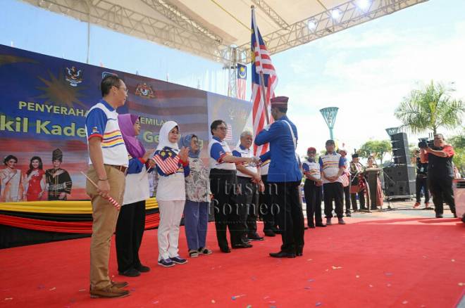 Abang Johari menyerahkan Jalur Gemilang kepada wakil Kadet Jalur Gemilang Jabatan Penerangan. - Foto ihsan Penerangan