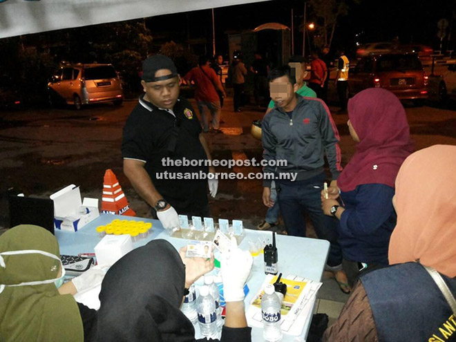  Petugas AADK ketika menjalankan pemeriksaan ujian air kencing terhadap individu dalam Ops Cegah Dadah di Kuching semalam.