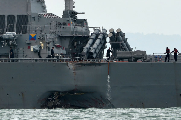  Kesan pelanggaran dapat dilihat pada bahagian tepi kapal pemusnah berpeluru berpandu USS John S. McCain di luar pangkalan tentera laut Changi di Singapura, semalam. — Gambar AFP