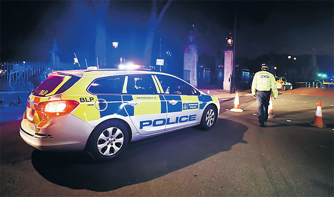  Seorang anggota polis Britain membuat kawalan selepas menahan seorang penyerang bersenjatakan pisau di luar Istana Buckingham di London. — Gambar Reuters