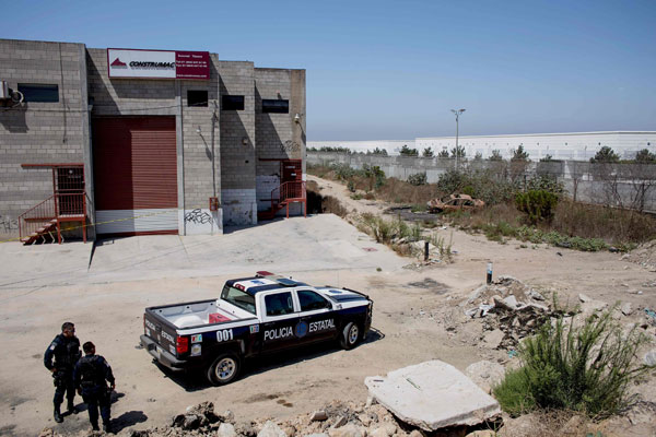  Pegawai polis negeri berkawal di sekeliling gudang di mana pintu masuk terowong penyeludupan manusia ditemui di Tijuana, barat laut Mexico kelmarin. — Gambar AFP