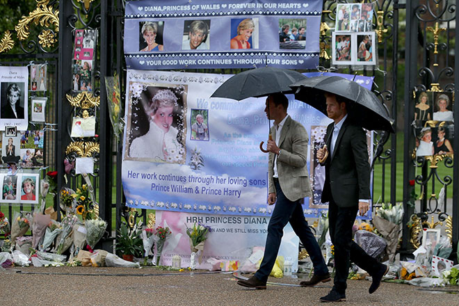  William dan Harry melihat tanda penghormatan oleh orang ramai untuk ibu mereka di hadapan Istana Kensington di London kelmarin. — Gambar AFP