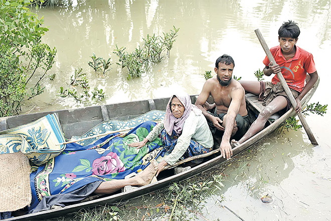  Gambar fail 6 September lalu menunjukkan penduduk Rohingya membawa mayat rakan mereka dengan bot setelah ditemui susulan insiden bot karam di Sungai Naf, dekat Ulubunia di Ukhiya. — Gambar AFP