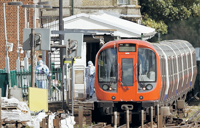  Pegawai forensik polis menjalankan siasatan di sekitar kereta api bawah tanah Tube di pelantar stesen Parsons Green London Underground di barat London, kelmarin susulan insiden dalam salah satu gerabak di mana satu bekas putih (gambar kanan) terbakar sejurus meletup. — Gambar AFP