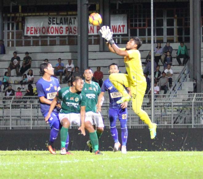 Penjaga gol UKM FC, Abdul Gapur Samsudin tangkas menyelamatkan gawang pasukannya dari ancaman penyerang Kuching FA (jersi hijau).