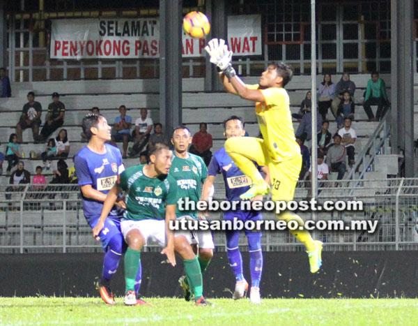  Penjaga gol UKM FC, Abdul Gapur Samsudin tangkas menyelamatkan gawang pasukannya dari ancaman penyerang Kuching FA (jersi hijau).