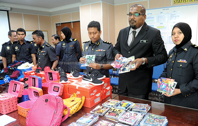  Jaiya (dua kanan) bersama anggotanya menunjukkan antara barangan tiruan yang dirampas bernilai RM88,191.20 pada sidang media di Melaka, semalam. — Gambar Bernama