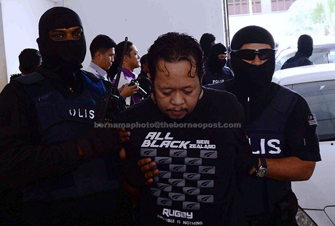  Anggota polis membawa Norazif yang merupakan salah seorang dari ahli Geng Pak Su untuk dihadapkan di Mahkamah Sesyen atas pertuduhan menyertai kumpulan jenayah terancang. — Gambar Bernama