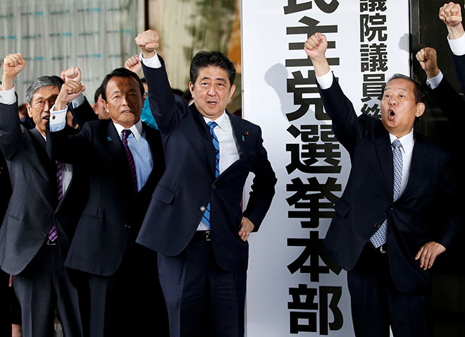  Abe (tiga kiri) bersama anggota partinya mengangkat penumbuk ketika mereka berikrar untuk memenangi pilihan raya tergempar yang dijangka diadakan pada 22 Oktober, di Ibu Pejabat Parti LDP di Tokyo, semalam. — Gambar Reuters  