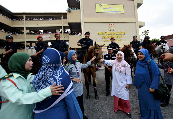  Zulkifli (berkuda, tengah) beramah mesra bersama Zainab (tiga kanan) sempena Program Komuniti Polisi di sekolah, Kuala Lumpur, semalam. — Gambar Bernama