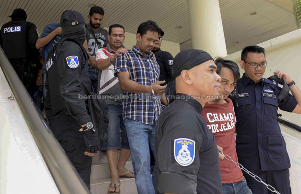  Anggota polis membawa sebahagian daripada 20 anggota Geng Pak Su di Mahkamah Sesyen dekat Alor Setar, semalam kerana terbabit dalam aktiviti penyeludupan di sekitar sempadan Malaysia-Thailand. — Gambnar Bernama