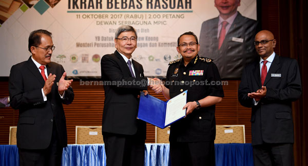  Mah menyerahkan dokumen Ikrar Bebas Rasuah kepada Dzulkifli pada Majlis Ikrar Bebas Rasuah peringkat kementerian tersebut di ibu negara semalam. Turut hadir Nasrun (kiri) dan K Yogeesvaran (kanan). — Gambar Bernama