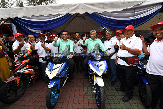  Ahmad Zahid (kanan) dan Ahmad Razif mencuba motosikal yang dipamerkan sewaktu melawat gerai pameran selepas merasmikan Karnival Pertubuhan Kebangsaan 2017 di Dataran Batu Burok dekat Kuala Terengganu, semalam. — Gambar Bernama
