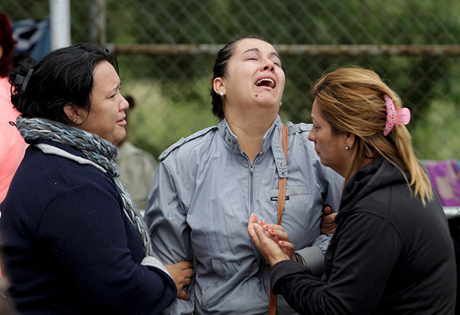  Saudara mara banduan menangis sementara helikopter mencurah air untuk memadam kebakaran selepas rusuhan meletus di penjara Cadereyta, Mexico, pada Selasa lepas. — Gambar Reuters