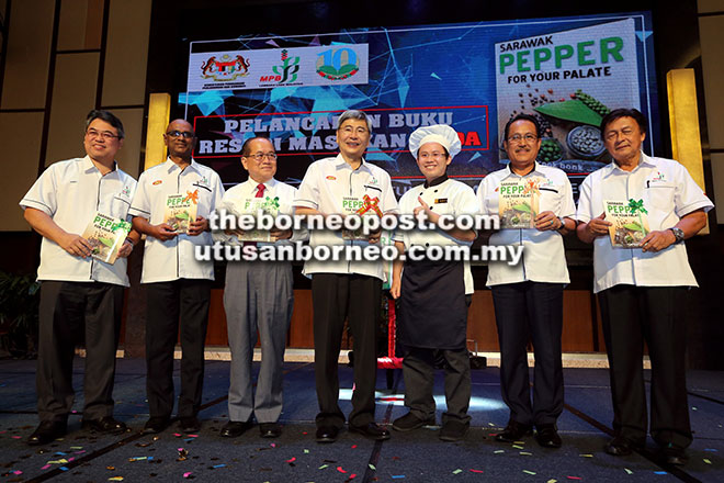  Mah (tengah) bersama Uggah (tiga kiri), Mawan (kanan) serta yang lain menunjukkan buku resipi lada bertajuk ‘Sarawak Pepper for Your Palate’ yang turut dilancarkan pada majlis semalam.