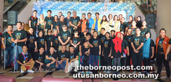  Adam (barisan belakang, lapan kiri) bergambar bersama sebahagian peserta sambutan Hari Tongkat Putih dan Hari Penglihatan Sedunia Peringkat Negeri Sarawak 2017 di Bintang Megamall Sabtu lalu.